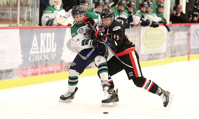 Cariboo Cougars forward Riley Krane and Fraser Valley Thunderbirds forward Justin Plett battle for a loose puck on Saturday night at Kin 1 in the second game of their best-of-three championship series. Citizen Photo by James Doyle