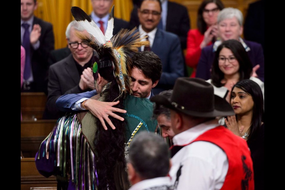 Prime Minister Justin Trudeau hugs a drummer on March 26 after delivering a statement of exoneration on behalf of the government to the Tsilhqot'in Nation and the descendants of six Tsilhqot'in chiefs.