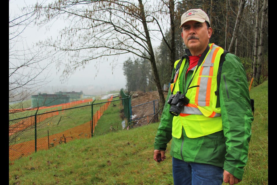 Streamkeeper John Preissl stands north east of Trans Mountain's terminal in Burnaby. Excavation at the site behind him may have led to a sediment spill downstream in Silver Creek.