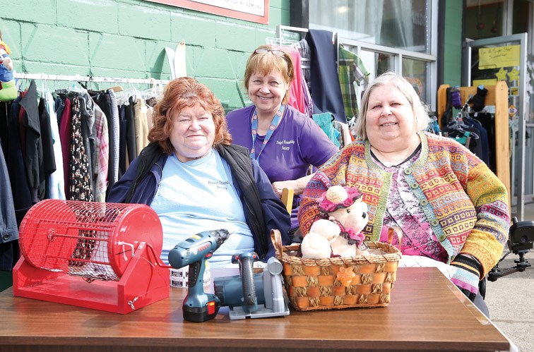 From left, Lois Bittner, Project Friendship Society program coordinator, Margaret Jackson, volunteer, and Mary Tashner, Project Friendship Society president, pose for a photo outside Thrifty Friends Boutique on Saturday morning during the Super Saturday Garage Sale with proceeds going to Project Friendship Society.