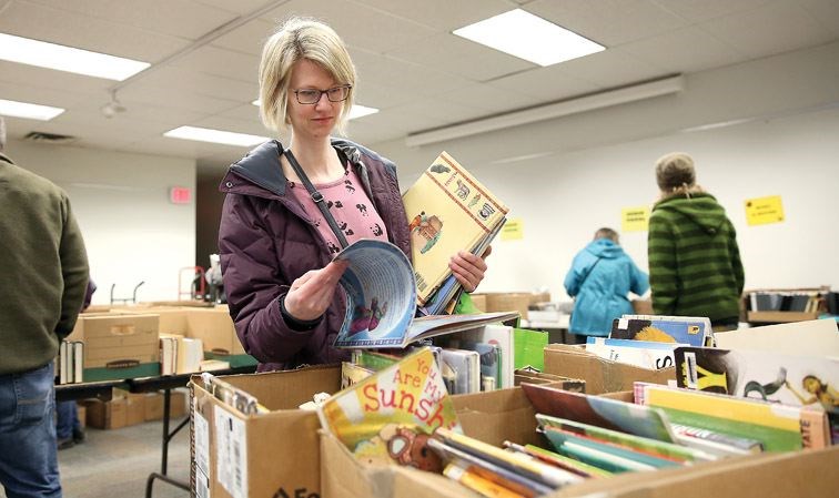 Annice Yeoman flips through a book at the Friends of the Library book sale on Saturday morning at the Keith Gordon room at the Bob Harkins Branch of the Prince George Public Library. Hundreds of books, DVDs, magazines and more were for sale by donation at the twice-annual sale.