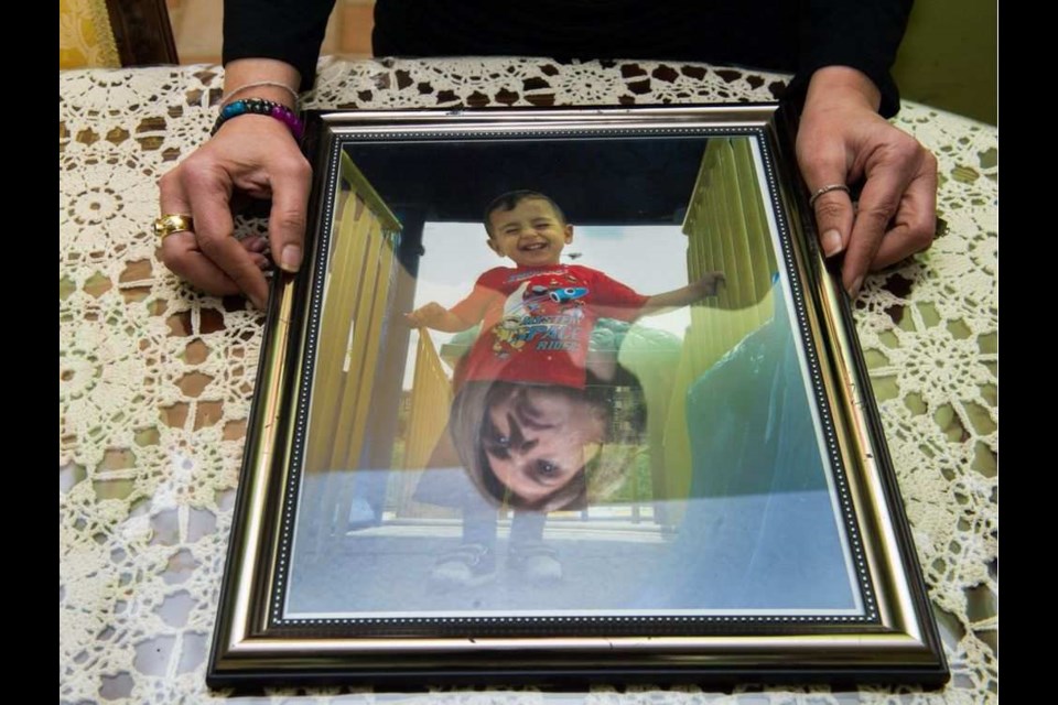 Tima Kurdi, her face reflected in a portrait of nephew Alan Kurdi, at her home in Coquitlam.