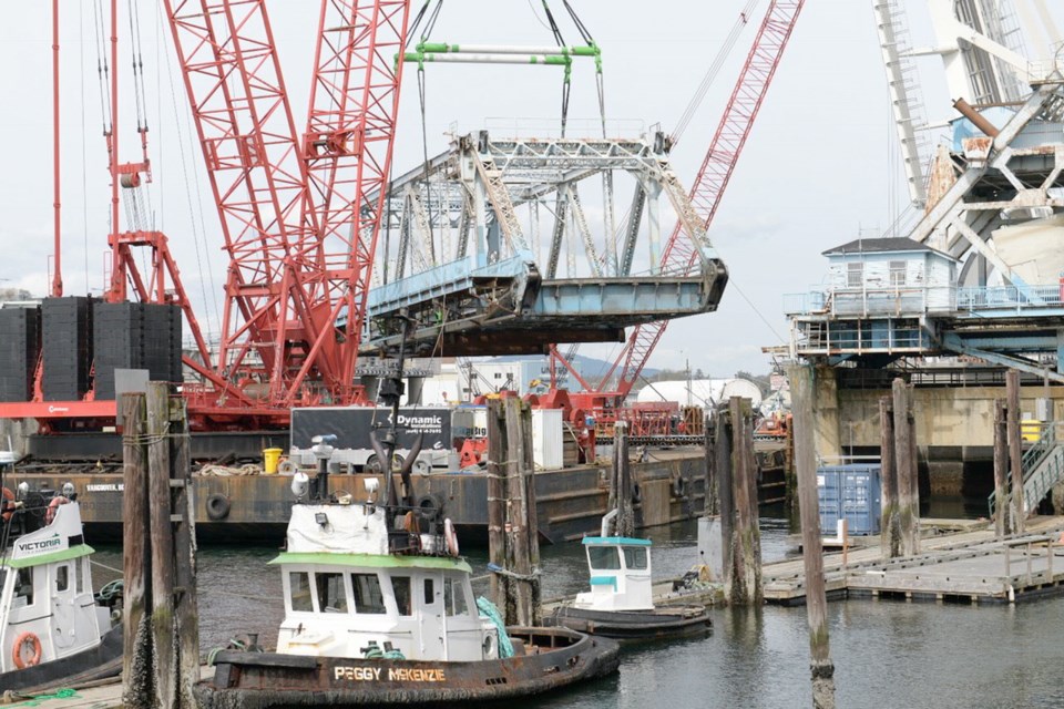 The main span of the old Johnson Street Bridge is lifted from its longtime perch to be taken away for recycling on Thursday, April 19, 2018.