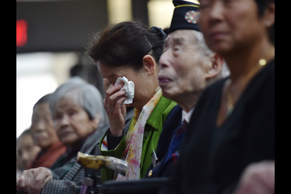 Kelley Lee, seated next to her war veteran father Monty Lee, got emotional Sunday as she listened to an apology from Mayor Gregor Robertson and two former city councillors. Photo Dan Toulgoet