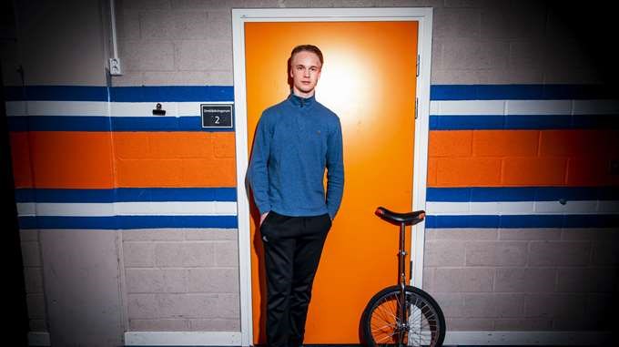 Elias Pettersson standing next to a unicycle.