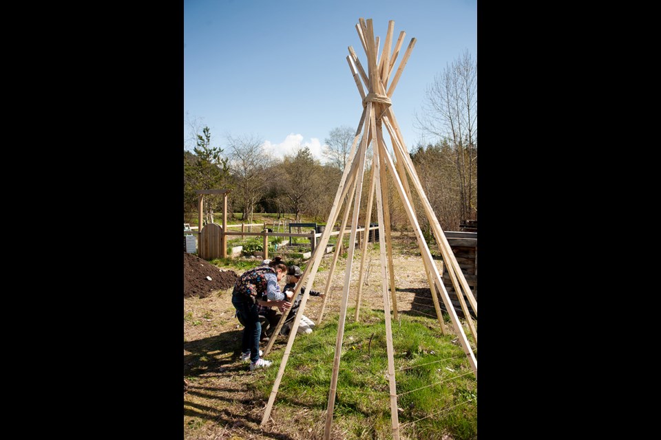 Frieda Palethorpe and Riley Drever build a tepee at the Earth Day Picnic at ValleyCliffe Elementary