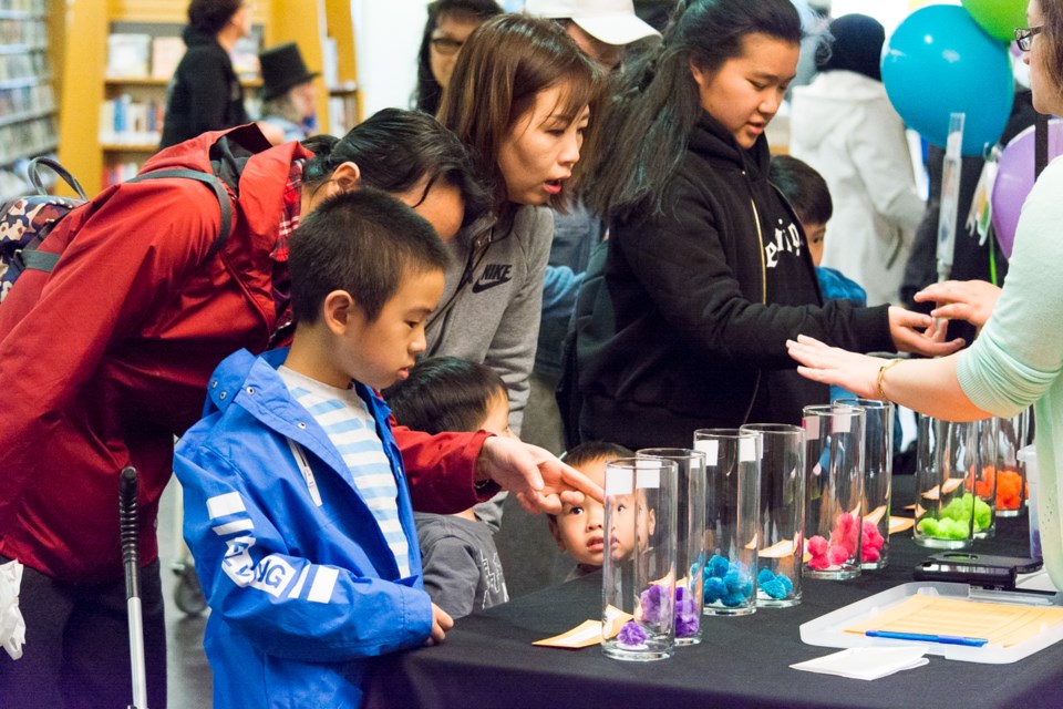 Visitors vote with colourful pompoms at the library’s Open House on April 25.