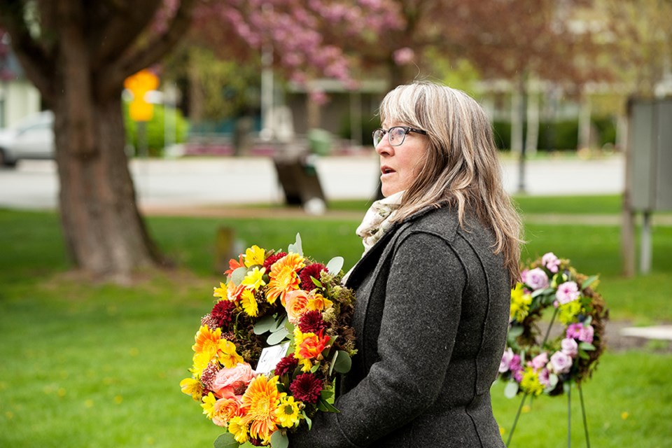 Rita Kyle of CUPE 779, the school district union, lays a wreath during the Day of Mourning ceremony