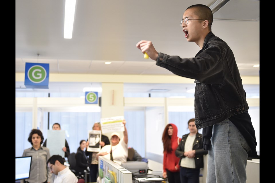 Activists walked to another city building at 10th and Cambie that serves as a centre for people to obtain permits and licences. The activists circulated throughout the centre, disrupting meetings between customers and staff, with Vincent Tao at one point climbing on top of a desk to demand social housing. Photo Dan Toulgoet