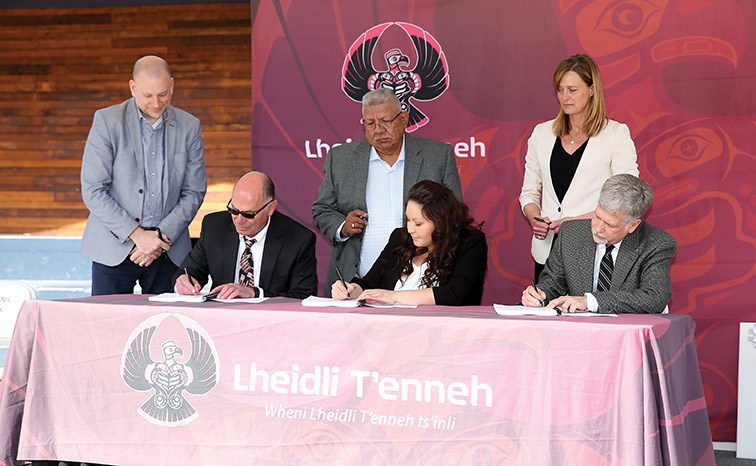 From left sitting, signatories Frank Soda, Tamara Seymour, and Robert Leece initial Treaty documents while witnesses, standing from left, Joe Wild, Chief Dominic Frederick, and Trish Balcaen look on during a Treaty initialing ceremony on Saturday morning at Canada Games Plaza.