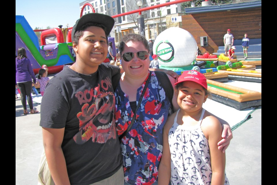 Emily Kearnan, with her children Logan, 11, left, and Kyana, 8, right, take in the activities during Healthy Kids Day presented by the Northern B.C. YMCA at the Canada Games Plaza Sunday.