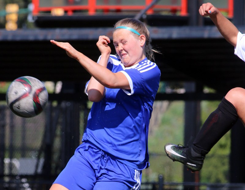 Centennial's Rylee Mackenzie flinches from a high kick in the second half of their first round match against Lord Tweedsmuir at the Fraser Valley girls high school soccer championships, Monday at Coquitlam Town Centre Park.