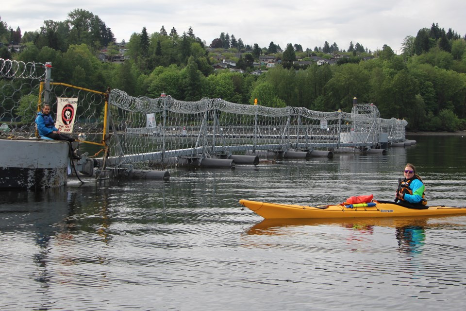 Two activists wrap-strapped themselves to the gate at the entrance by water to the Westridge marine terminal in Burnaby Wednesday morning. Four others blocked the gates with their kayaks on the water.