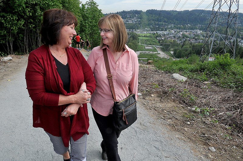 Tammy Bryant (left) and Tanya Leibel share a moment at the top of the stair section of the Coquitlam Crunch on Tuesday. The two women first met when Leibel was having a heart attack on the climb and Bryant, who was hiking with a friend just behind, was able to apply CPR until first responders arrived and took over. They recently reconnected after Leibel posted a sign along the popular hike seeking her saviour.