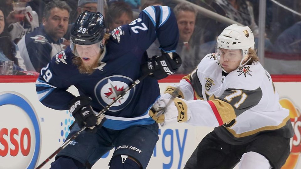 Patrik Laine and William Karlsson battle for the puck.