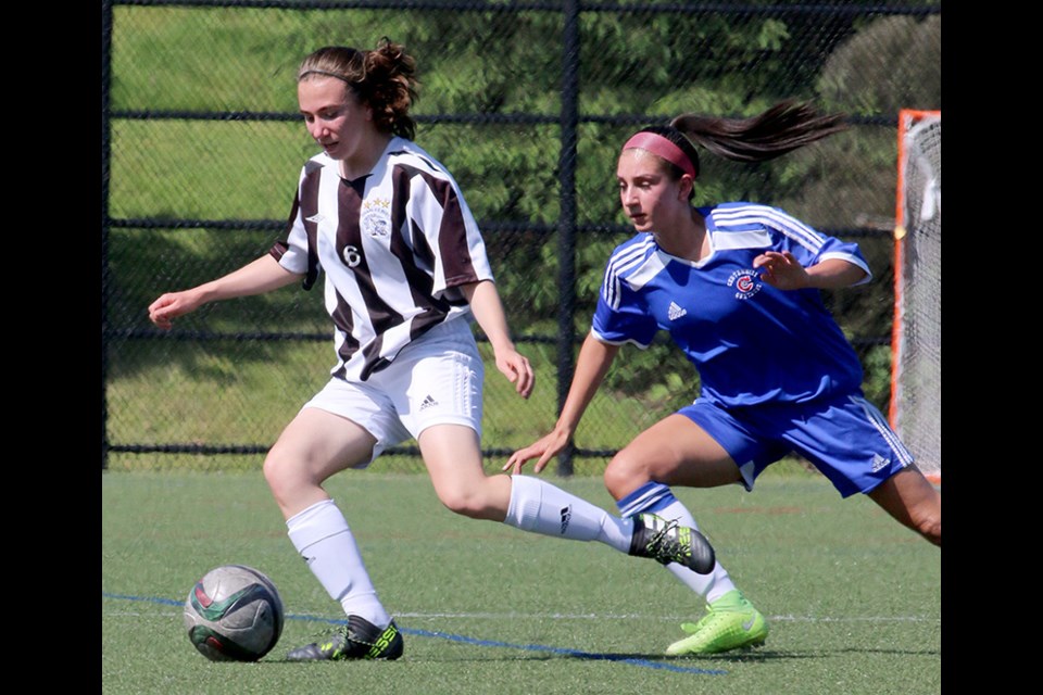 MARIO BARTEL/THE TRI-CITY NEWS Centennial Centaurs' Matisse Jones tracks Dr. Charles Best forward Marina Verones in the first half of their semi-final match in the Fraser Valley high school girls soccer finals, Monday at Coquitlam Town Centre Park. Centennial won the match, 4-2, in overtime.