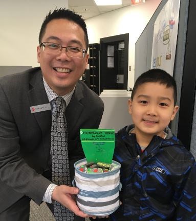 Graham, 7, with the Scotiabank Oakridge manager, Wilfred Chan. Image: Debbie Lee Jiang