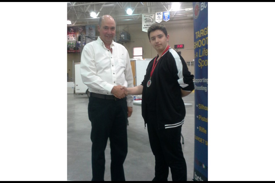 Richmond air gun champion Bobby Reid, 14, receives his silver medal at last weekend's provincials