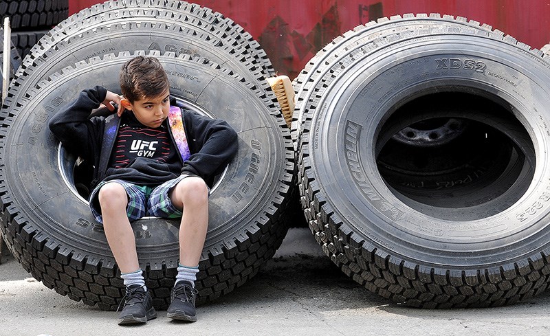 MARIO BARTEL/THE TRI-CITY NEWS
Sam Azizi, 10, takes a break amidst the tires at Port Moody's public works yard on Murray Street during an open house on Friday. The event was the culmination of Public Works Week.
