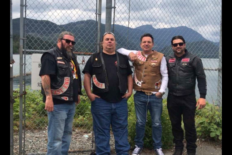 Burnaby firefighter Nick Elmes, right, poses with members of the Hells Angels Motorcycle Club.