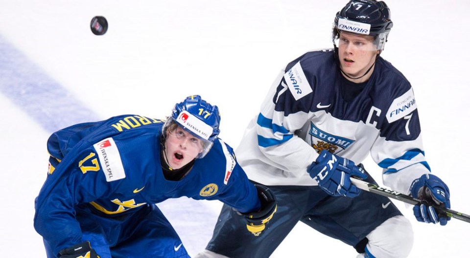 Olli Juolevi battles Fredrik Karlstrom for the puck at the World Junior Championships.