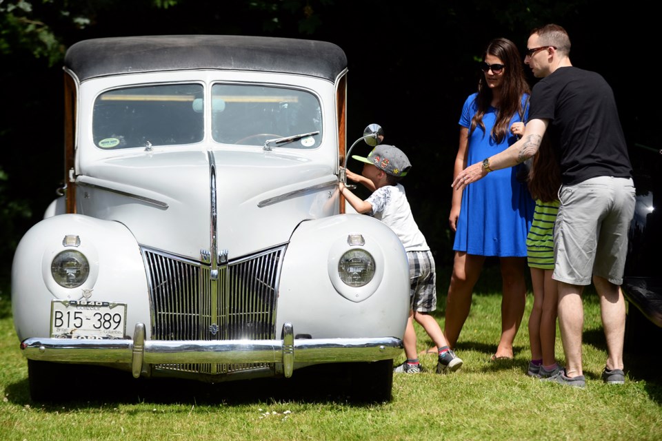 Five-year-old Ethan Baskin peers at one of the cars that was part of a classic car display at Burnaby Village Museum Sunday.