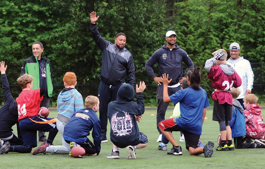 GSL president Mark Currie (left) and former CFL star and North Vancouver native Paris Jackson (white hat) get participants organized for a day of football fun.