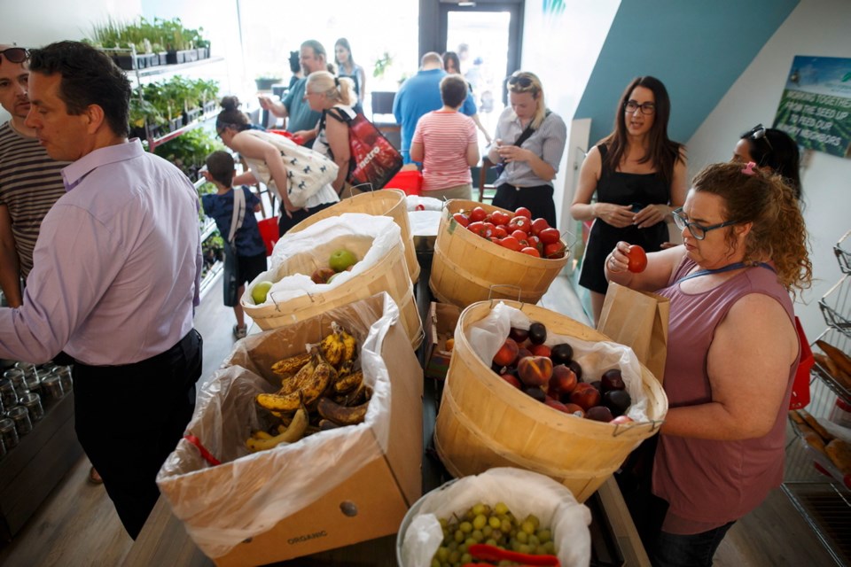 People shop for produce at Feed it Forward&Iacute;s pay-what-you-can grocery store at its grand opening Saturday in Toronto. The new model grocery store is the first of its kind in Toronto and is encouraging those from different socioeconomic backgrounds to help curb food waste.