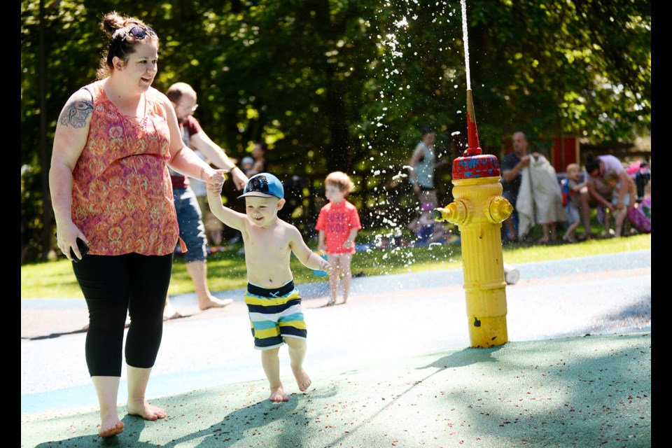 Cooling down: Two-year-old Kaden is all smiles as he enjoys the Queen’s park water park with his mom Sarah Benson at the Queen's Park.