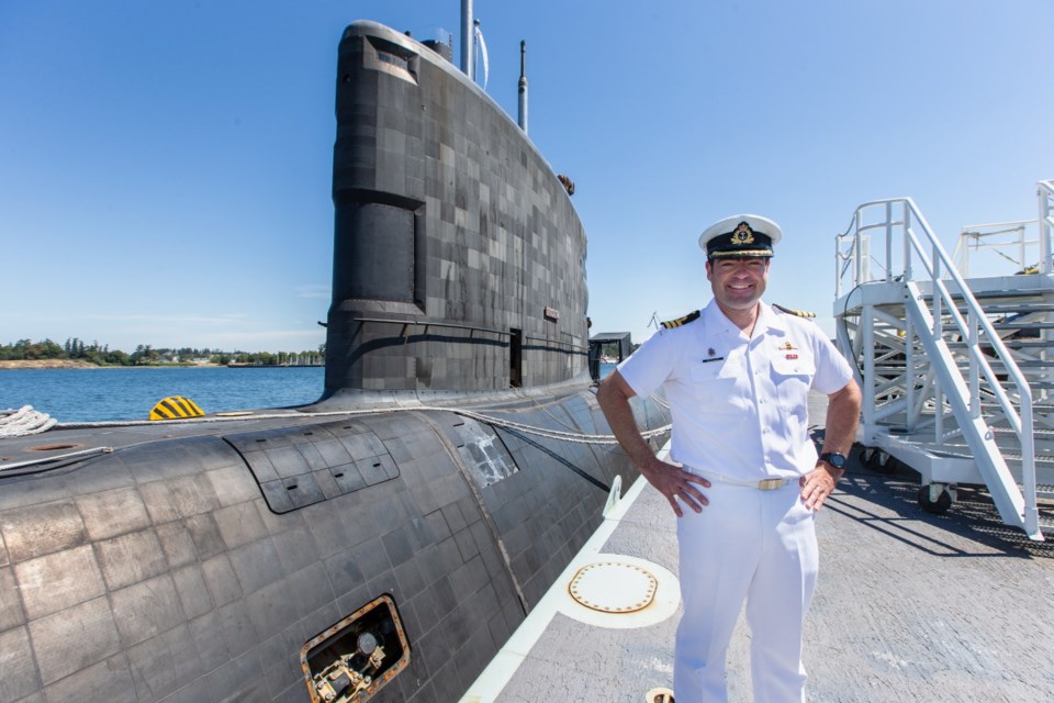 Cmdr. J.S. (Steph) Ouellet, the new commanding officer of HMCS Victoria, stands astride his former command, HMCS Chicoutimi, on Thursday.
