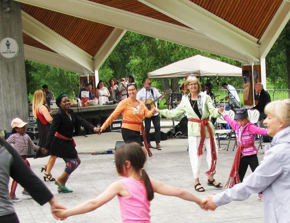 Monique Rheault Carlson, in the orange jacket, and Evelyne Bergeron, in the green jacket, dance with joy during a square dance led by Folklofolie during Saint Jean Baptiste Day held at Lheidli T'enneh Memorial Park Sunday.
