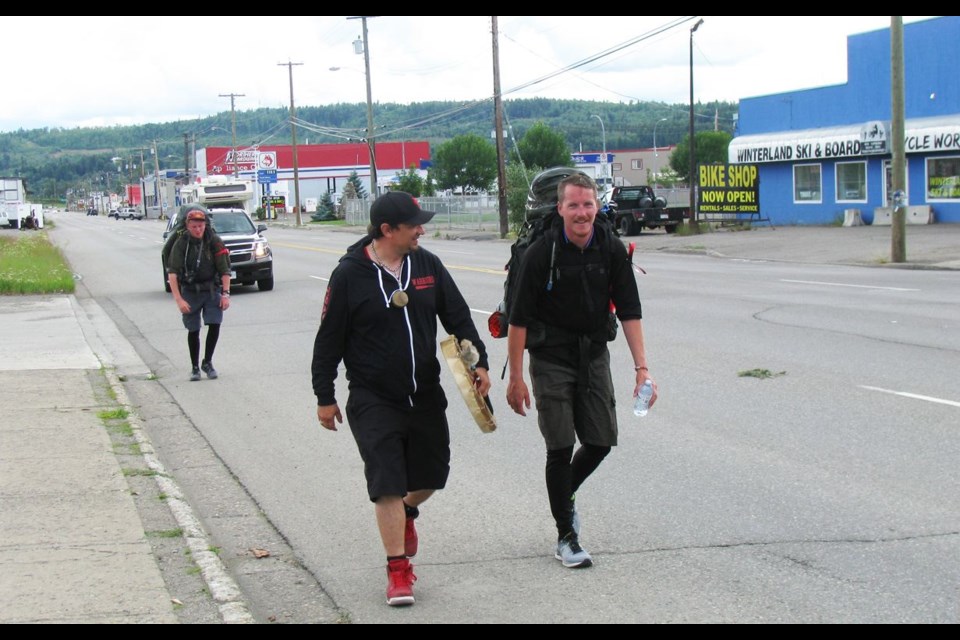 Matthew Jefferson, right, walks with Wesley Mitchell of the Khast'an Drummers of Prince George, as he heads towards the Lheidli T'enneh House of Ancestors on Third Avenue for a brief stop during his Walk to Remember, which will take him from coast to coast in an effort to renew awareness of the missing and murdered Indigenous women in Canada.
