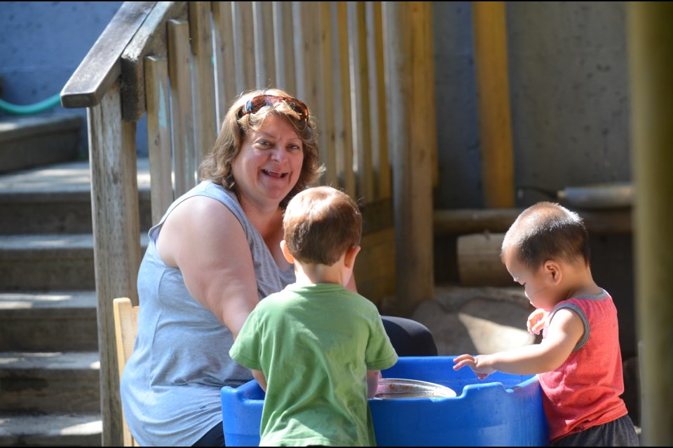 Nita Pedersen, who has worked at SFU Childcare Society for 28 years, plays with Logan (left) and Dominic (right).