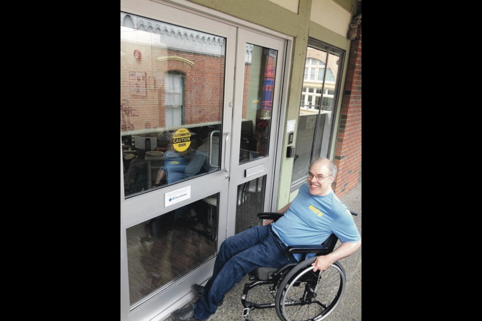 Scott Garnet, a volunteer at MOVE Adapted Fitness, uses the new automatic front doors that were installed with the donation from the Pacific Blue Cross Health Foundation.