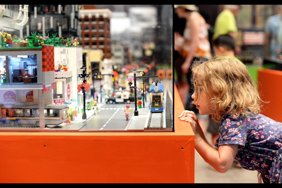 Five-year-old Alison Chadsey takes a peek at the city at the People Gotta Move exhibition.