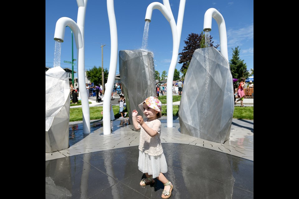 Two-year-old Talia Grossi dances in the water feature at the Charles Street pocket park.