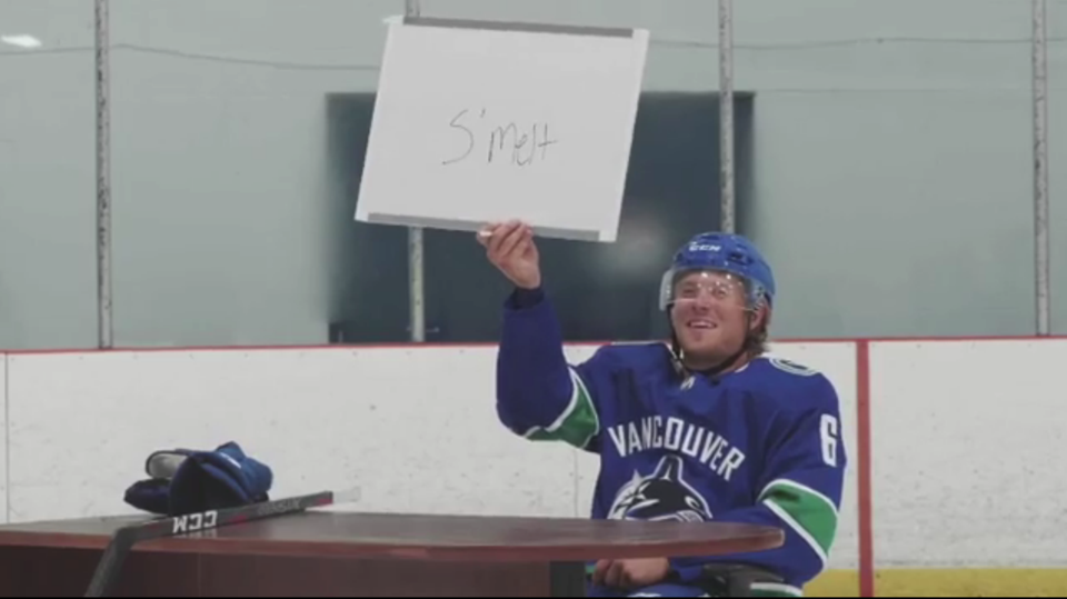 Brock Boeser holds up a s'melt sign.