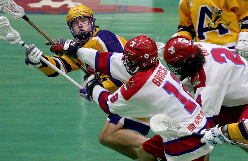 Coquitlam Adanacs forward Chase Scanlan is checked by New Westminster Salmonbellies defenders Gavin Bruce III and Dalton Lupul in the first period of the first game of their best-of-seven BC Junior A Lacrosse League final, Wednesday at New Westminster's Queen's Park Arena. Coquitlam won the game 9-3.