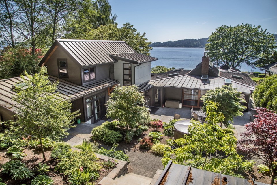 The renovated home overlooks the water and features a central courtyard in the private backyard that has no water view, but the forest view is just as important, says the architect.