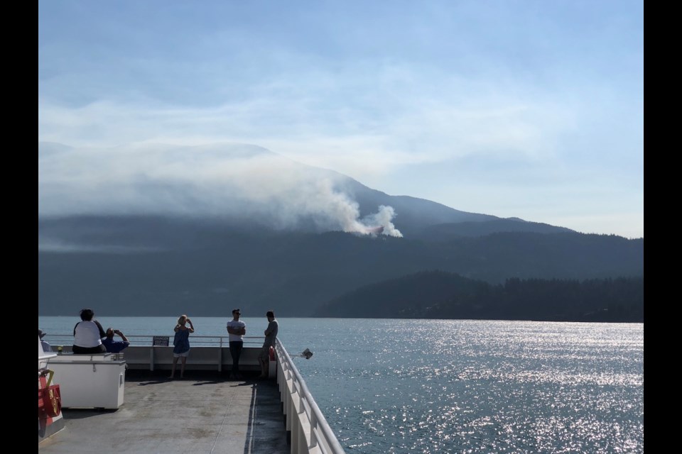 A view from the Queen of Capilano of fire retardant being dropped on the fire.