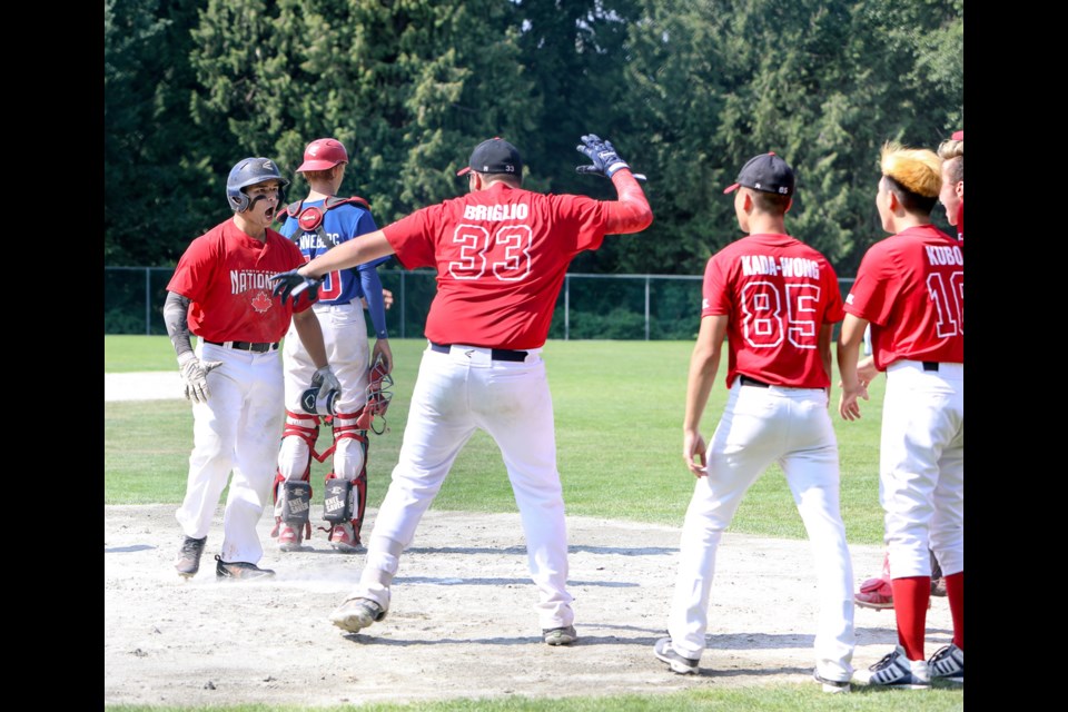 North Fraser teammates greet Burnaby’s Nicolas Santarelli, left, at home plate after his two-run homer, which would stand up as the difference in the 18-under AAA semifinal.