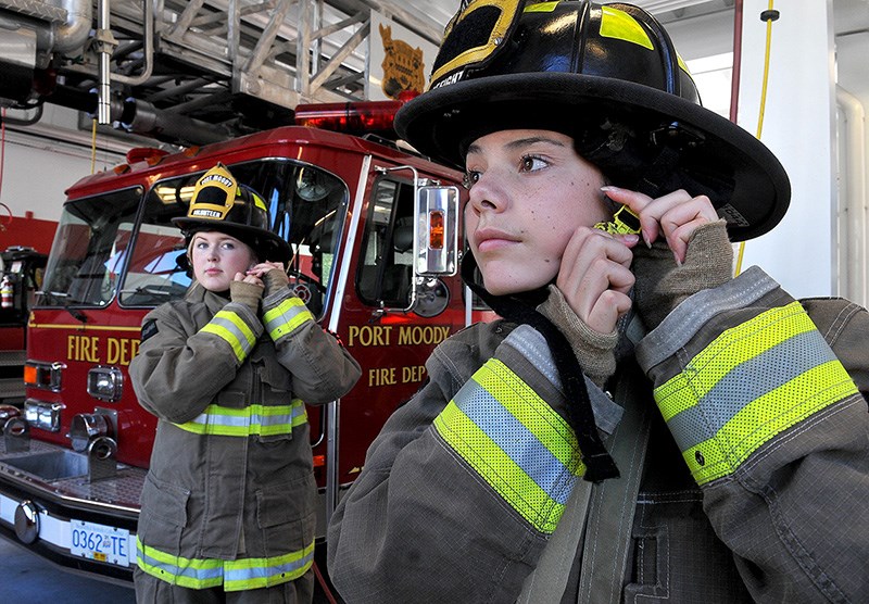 Rebecca Lyon and Chloe Goodison try on firefighter bunker gear at Port Moody's Inlet fire hall as they prepare to Camp Ignite, a four-day camp for young women to learn about the challenges and rewards of a possible career in firefighting.