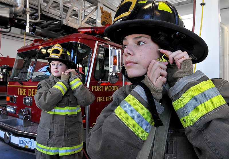 Rebecca Lyon and Chloe Goodison try on firefighter bunker gear at Port Moody's Inlet fire hall as they prepare to Camp Ignite, a four-day camp for young women to learn about the challenges and rewards of a possible career in firefighting.