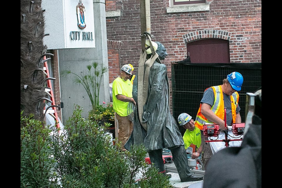 Crews remove the statue of John A. Macdonald in front of Victoria City Hall on Aug. 11, 2018.