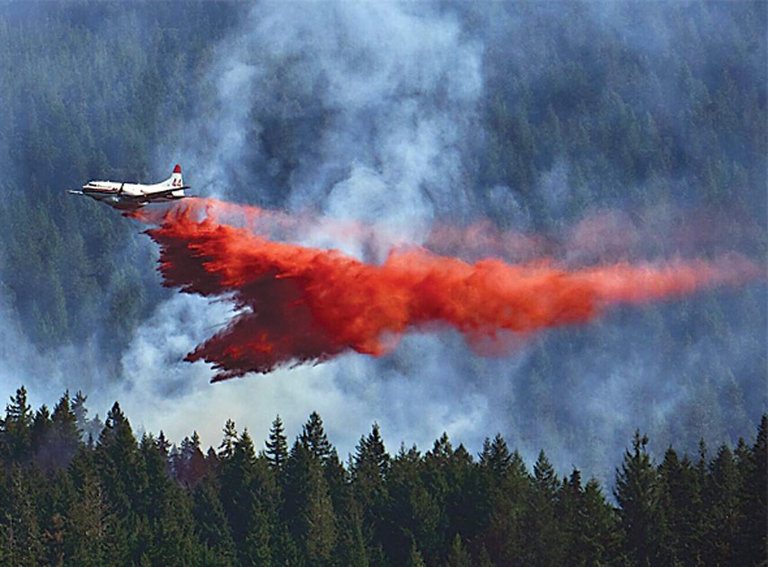 An aerial tanker drops retardant on a forest fire burning in West Vancouver’s Whyte Lake area Thursday. As of yesterday fire crews said the blaze was 100 per cent contained but the area was still too dangerous to assess.