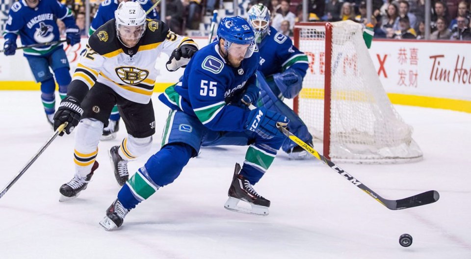 Alex Biega chases down the puck for the Vancouver Canucks against the Boston Bruins.