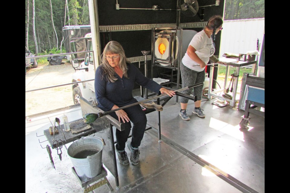 Denise Wasnik works on her glass-blowing technique at the mobile unit Mandy Patchin of Glass House Xperience has brought to Prince George. Denise made a drinking glass.