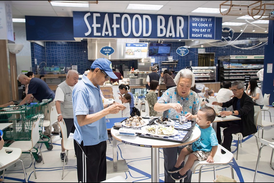 People eat at a seafood bar at T&T Supermarket's newest location, in Richmond, B.C., on Tuesday August 21, 2018. Shoppers can purchase fresh seafood in the store and have it steamed or baked to be eaten on site. Grocery stores increasingly blur the line between supermarkets and restaurants with large chains adding take-out meals to their shelves, hot food counters where chefs make dishes to order and even full-service restaurants. Dubbed grocerants, these combination spaces serve a time-strapped population that values convenience. THE CANADIAN PRESS/Darryl Dyck