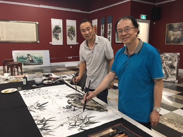 Local artists Tao Du and Jiang Zhu are creating a Chinese traditional painting at the exhibition. Daisy Xiong photo