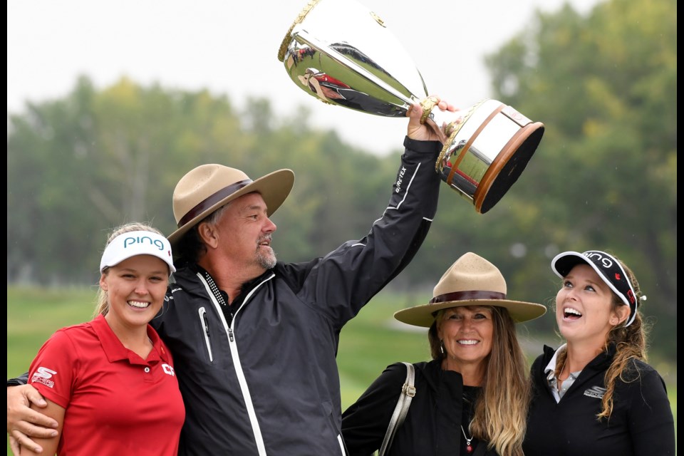 Brooke Henderson (left) with her parents Dave and Darlene Henderson, along with sister and caddy Brittany have some fun with Mountie hats and the CP Open championship trophy on Sunday.